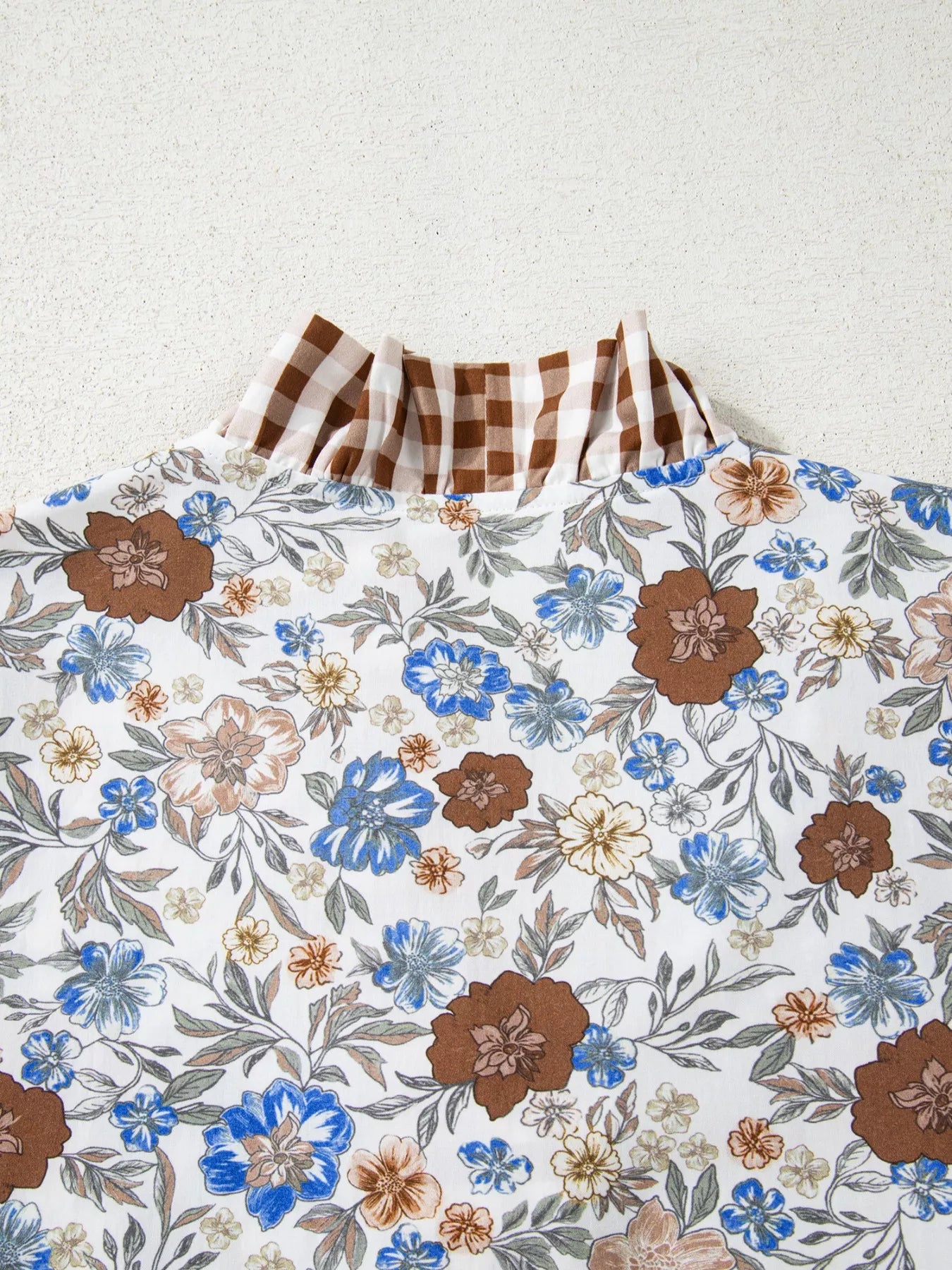 Floral blouse with gingham ruffle V-neckline and frilled sleeves styled with blue jeans