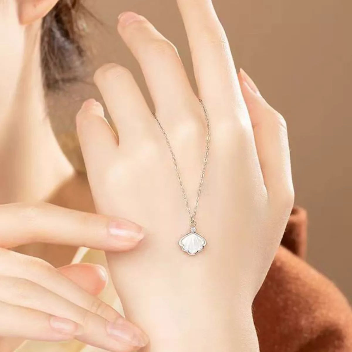 Sterling silver shell pendant necklace with zircon accent on a dainty chain, displayed in a matching navy jewelry box.