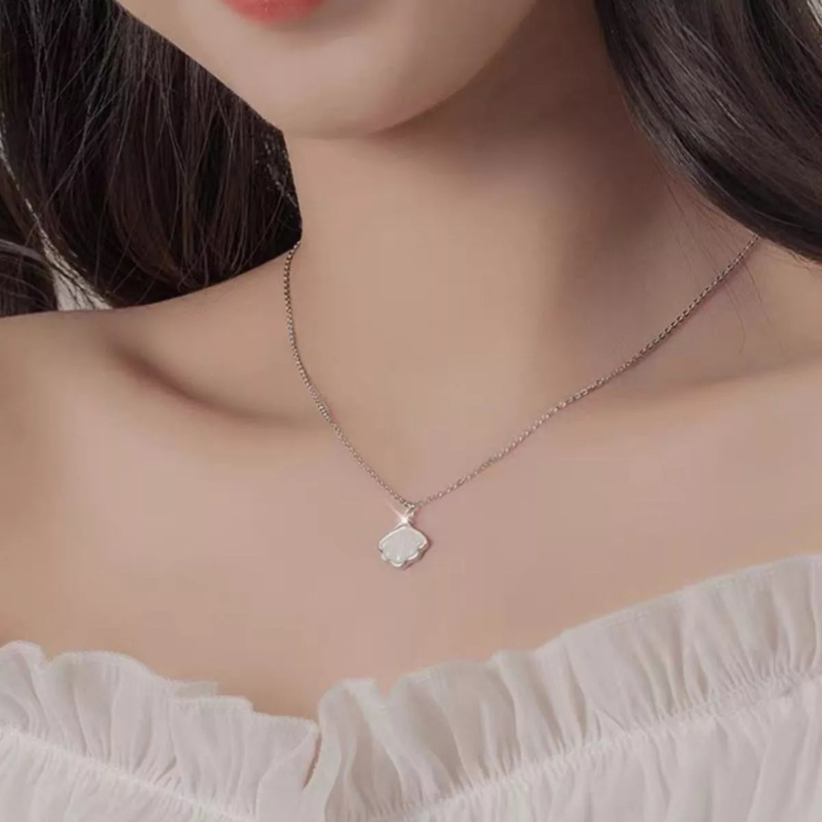 Sterling silver shell pendant necklace with zircon accent on a dainty chain, displayed in a matching navy jewelry box.