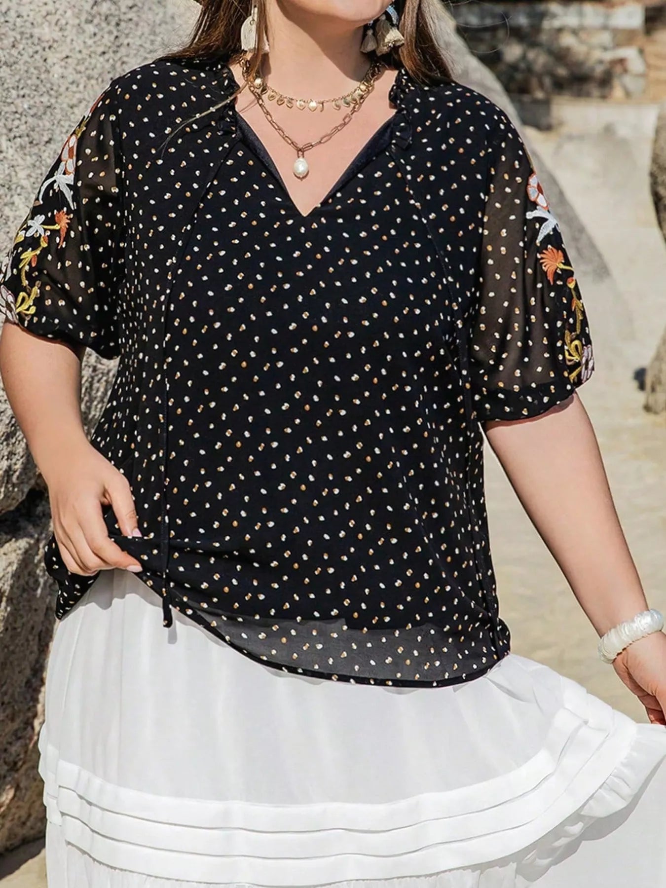 Plus size black embroidered tie top with floral sleeves and polka dot pattern – boho chic blouse for casual or dressy outfits.