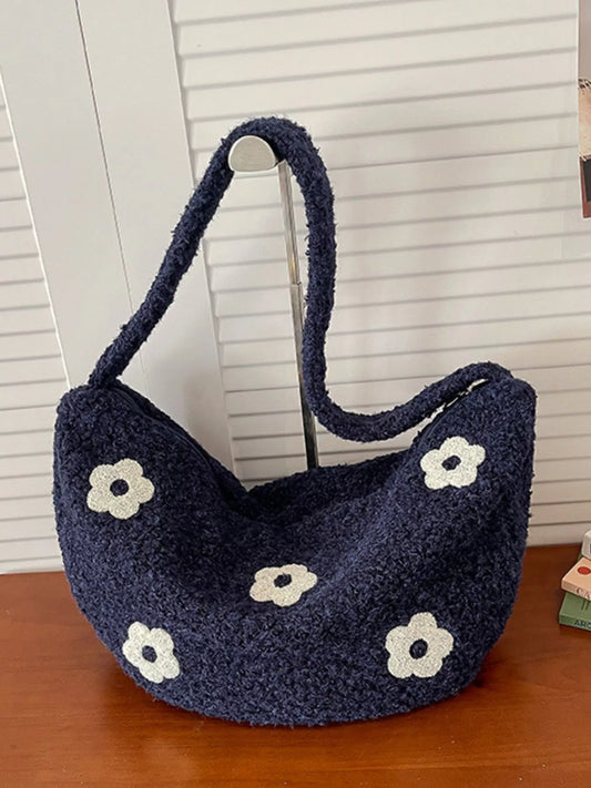 Navy plush shoulder bag with white flower appliqués and curved silhouette