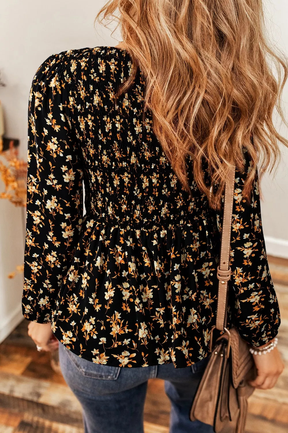 Black floral smocked long sleeve blouse with peplum hem