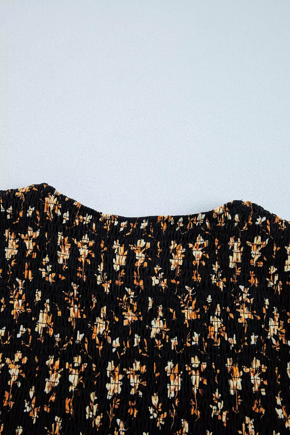 Black floral smocked long sleeve blouse with peplum hem