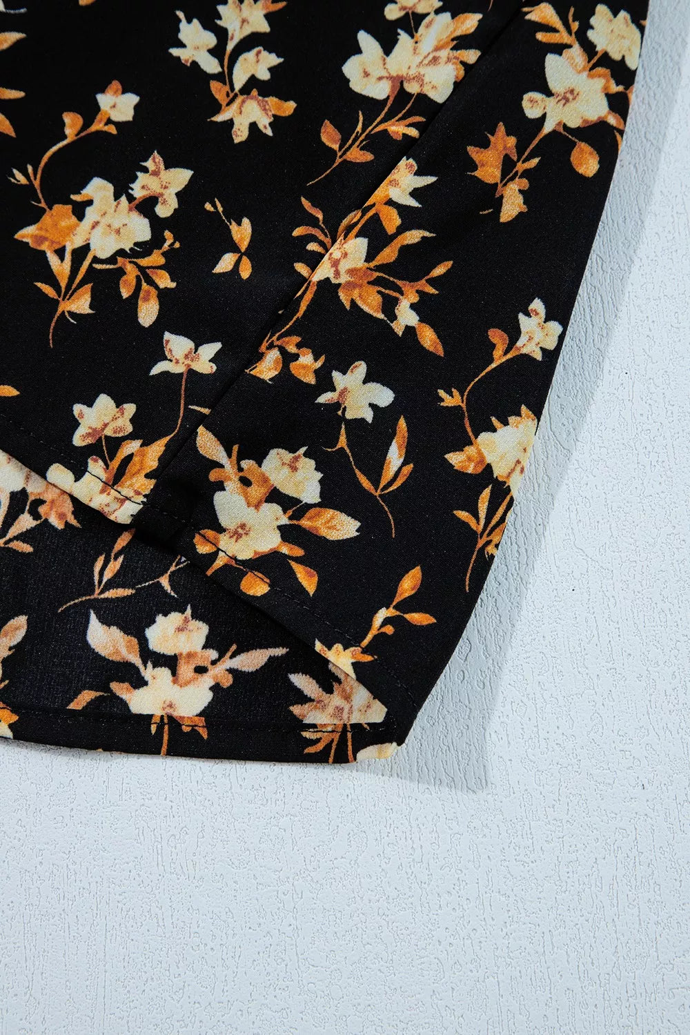 Black floral smocked long sleeve blouse with peplum hem
