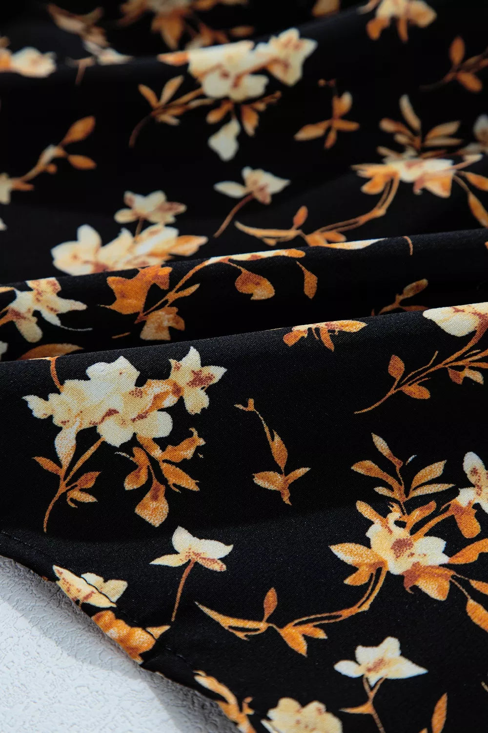 Black floral smocked long sleeve blouse with peplum hem