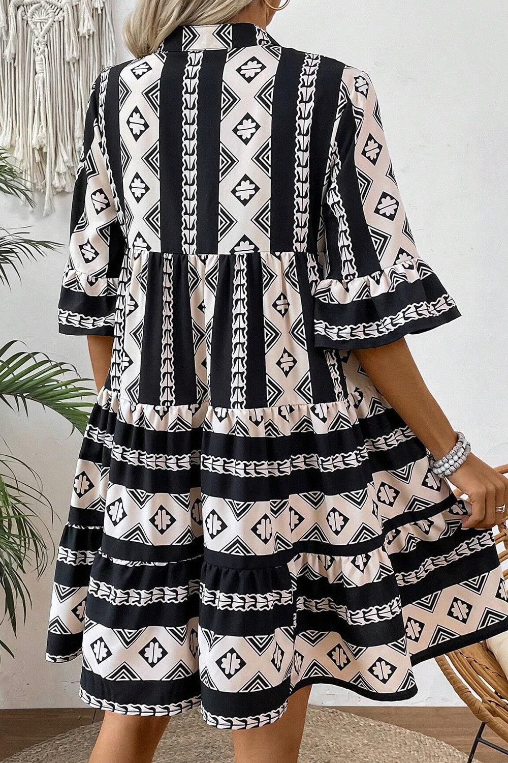 Black and cream geometric print tiered boho dress with wide sleeves and split neckline