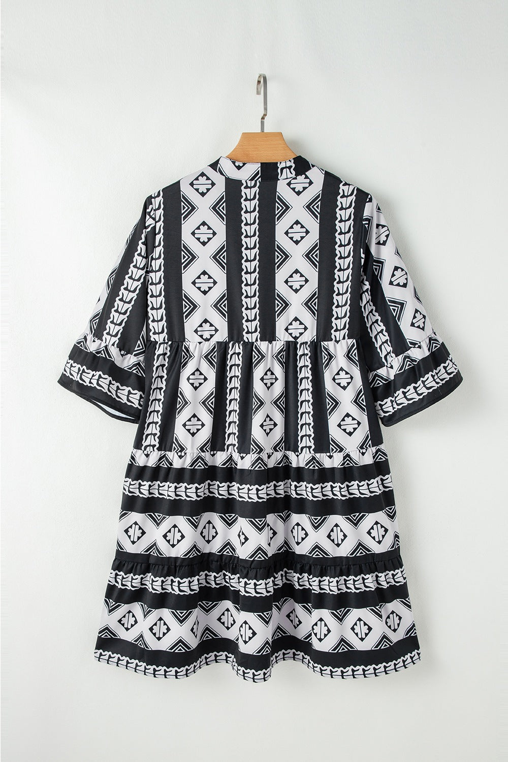 Black and cream geometric print tiered boho dress with wide sleeves and split neckline