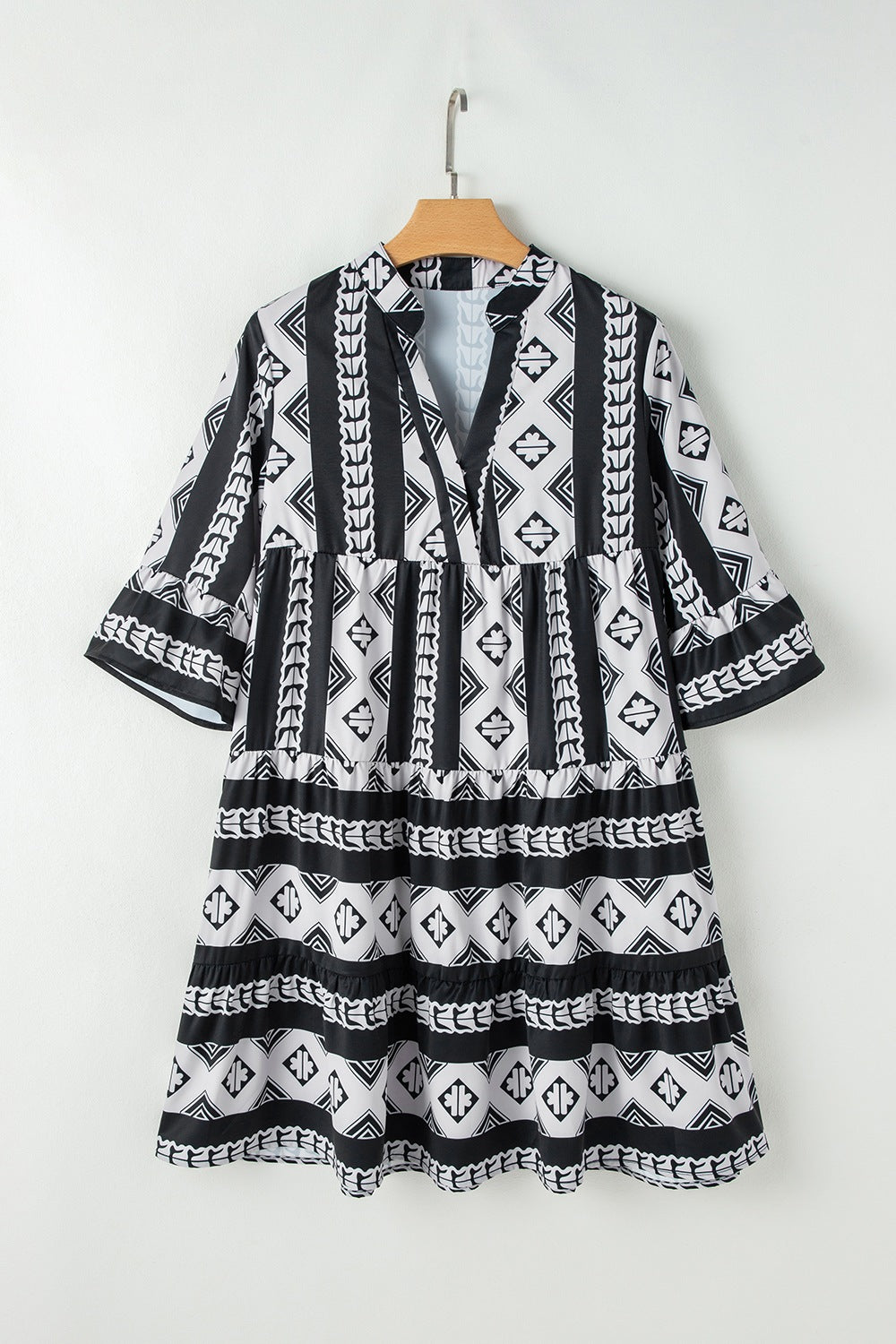 Black and cream geometric print tiered boho dress with wide sleeves and split neckline