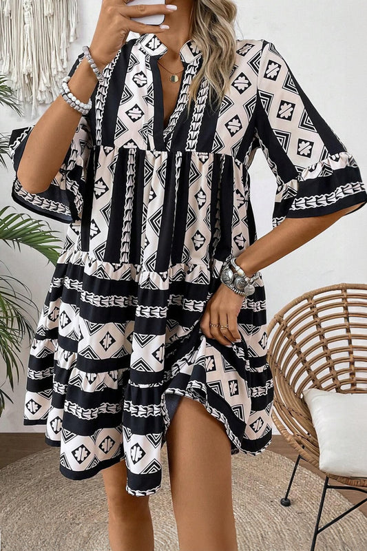 Black and cream geometric print tiered boho dress with wide sleeves and split neckline