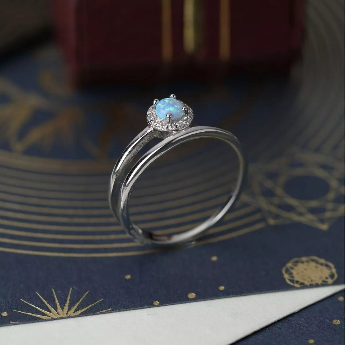 Dainty sterling silver opal ring with zircon halo and double wrap band.