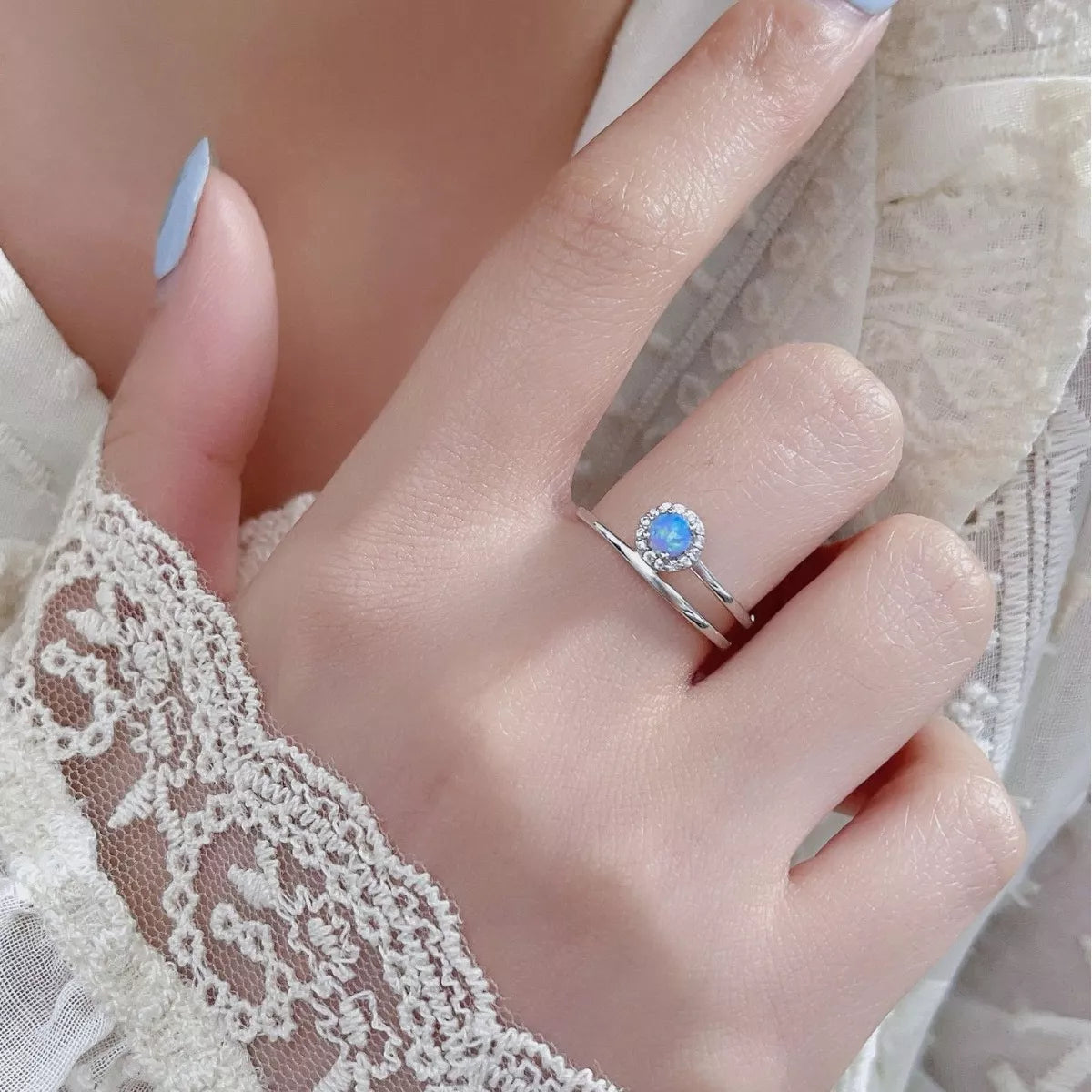 Dainty sterling silver opal ring with zircon halo and double wrap band.