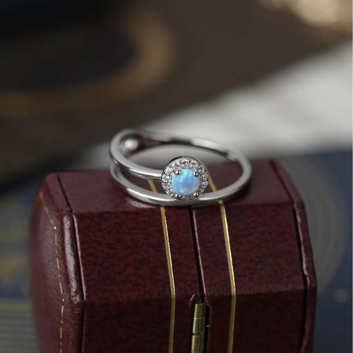 Dainty sterling silver opal ring with zircon halo and double wrap band.