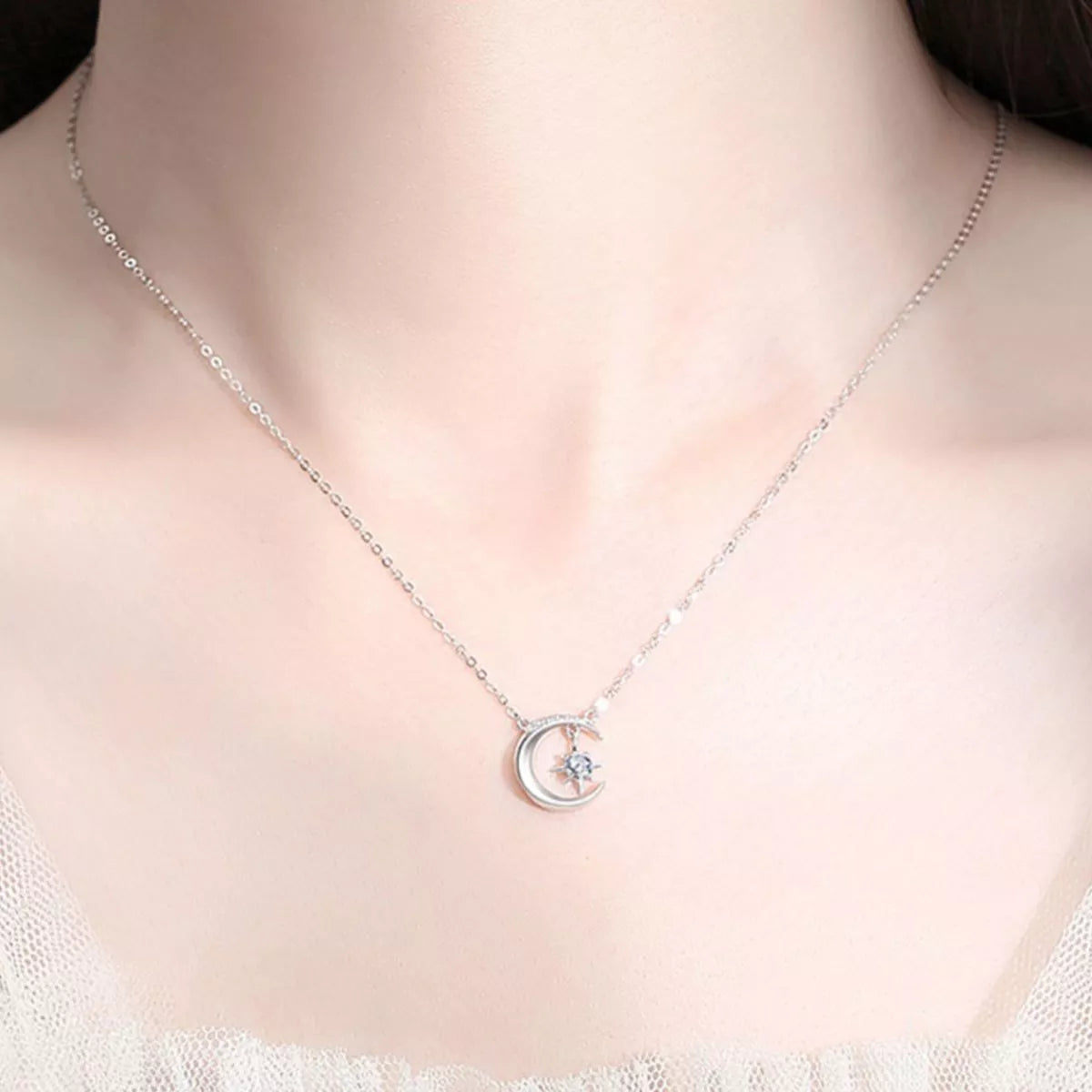 Sterling silver crescent moon necklace with a sparkling moissanite star pendant on a delicate silver chain.