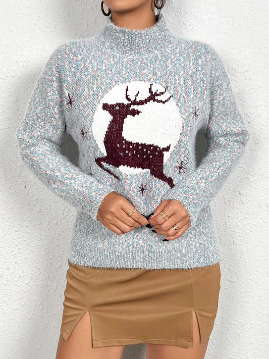 Soft knit sweater featuring a reindeer silhouette against a full moon design, styled with a tan mini skirt.