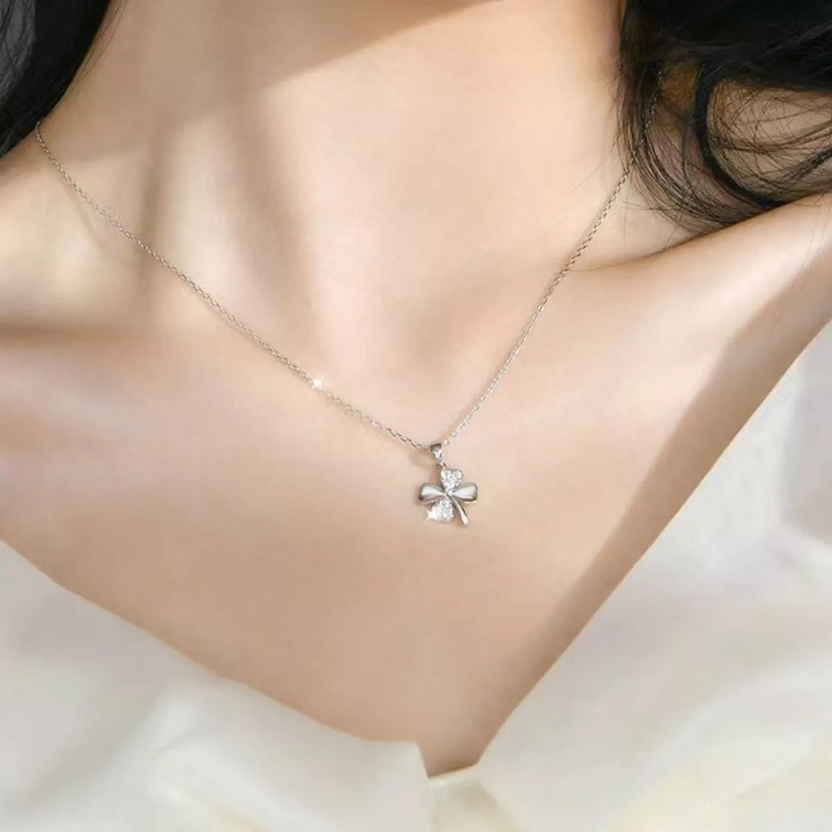 delicate sterling silver four leaf clover necklace with sparkling zircon pendant worn on minimalist chain