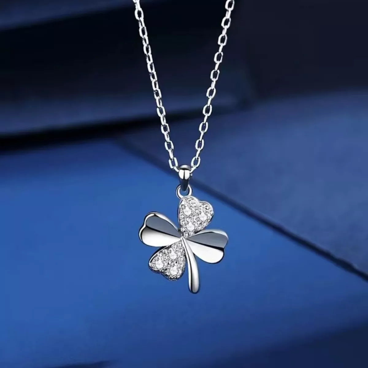 delicate sterling silver four leaf clover necklace with sparkling zircon pendant worn on minimalist chain