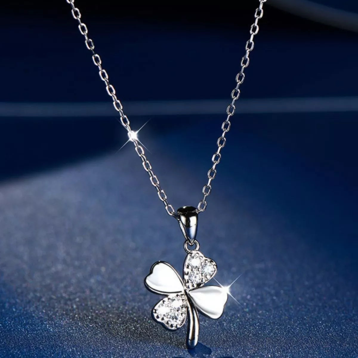 delicate sterling silver four leaf clover necklace with sparkling zircon pendant worn on minimalist chain