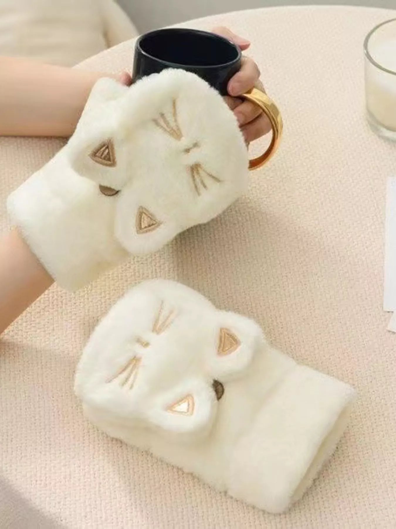 Cream plush fingerless gloves with embroidered cat paw face details