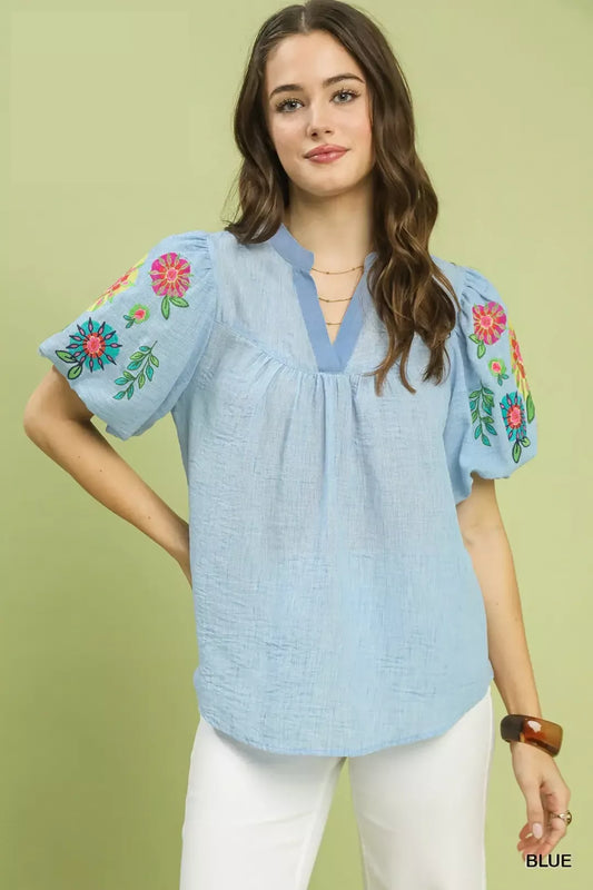 light blue embroidered peasant blouse with colorful floral puff sleeves and relaxed boho fit