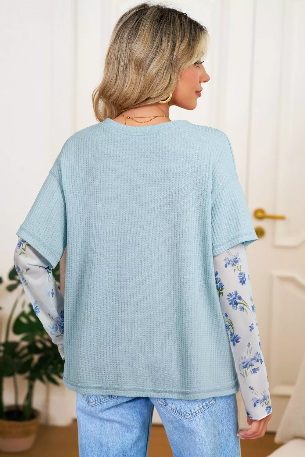 soft blue waffle-knit top with floral mesh layered sleeves and relaxed feminine silhouette