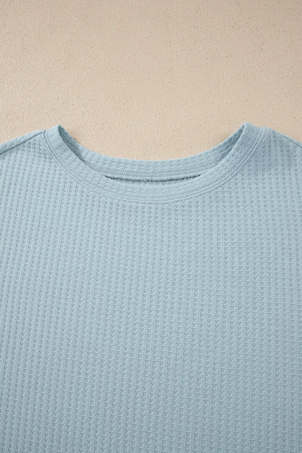 soft blue waffle-knit top with floral mesh layered sleeves and relaxed feminine silhouette