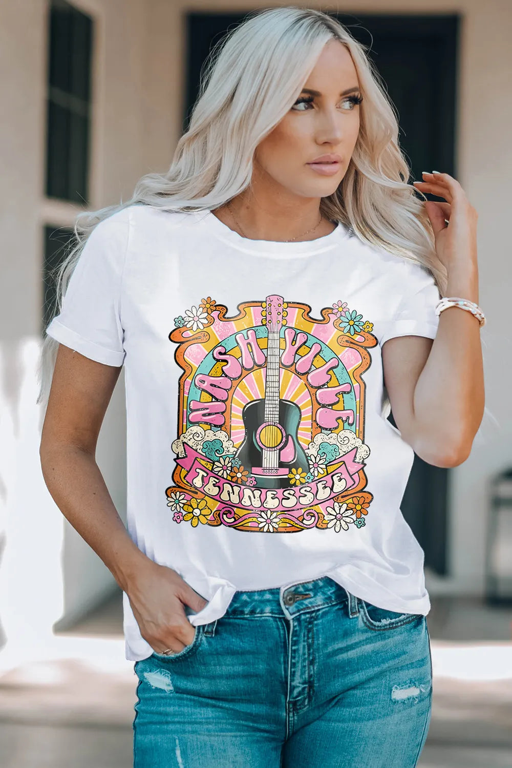 Retro Nashville graphic tee featuring colorful guitar and floral design styled with denim