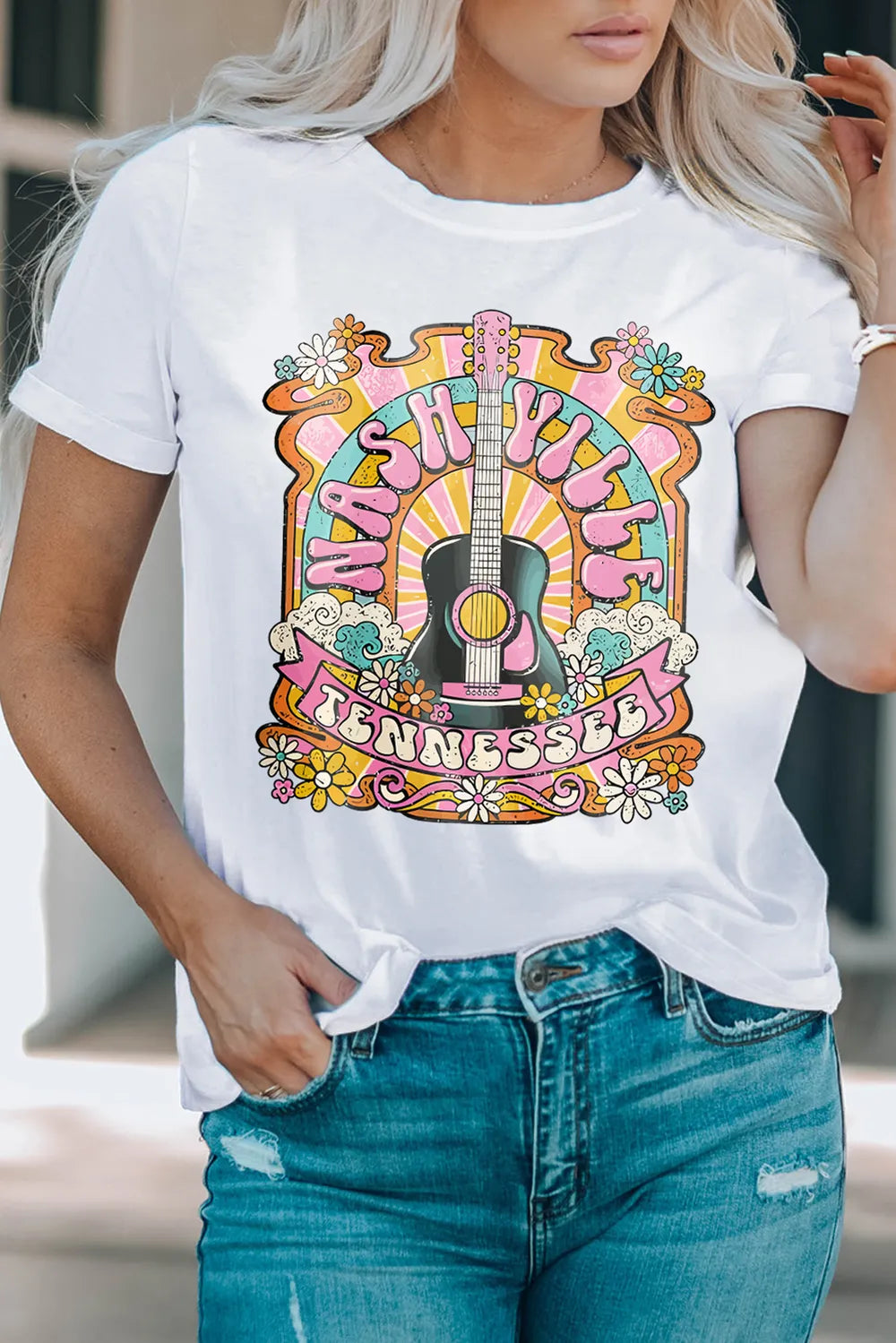 Retro Nashville graphic tee featuring colorful guitar and floral design styled with denim