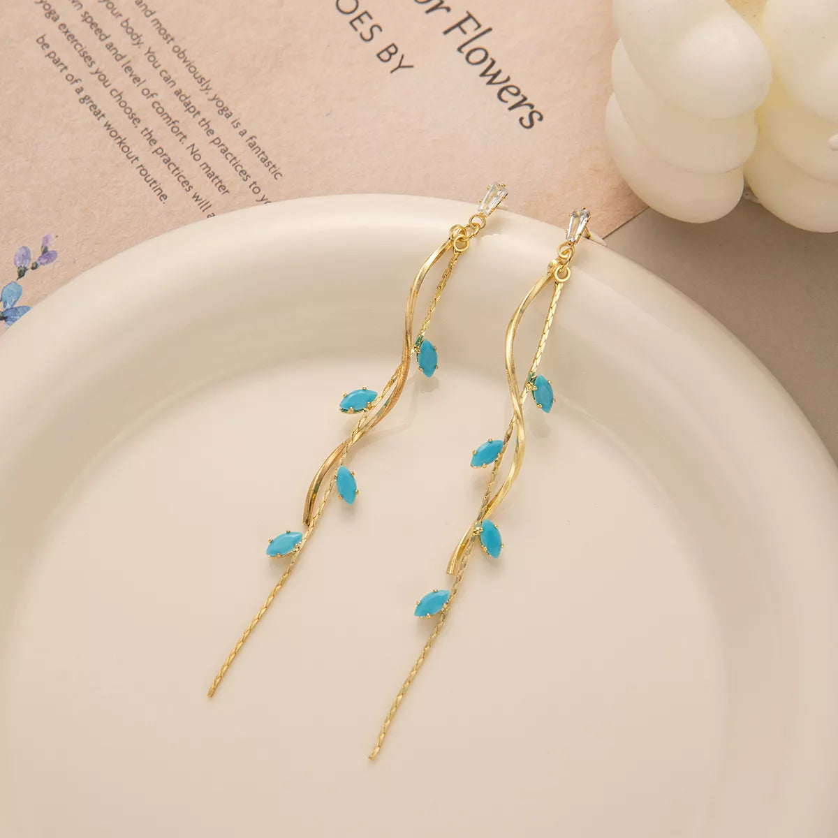 Woman wearing 18K gold-plated turquoise drop earrings with vine design — elegant ocean-inspired jewelry from A Whimsical Affair.