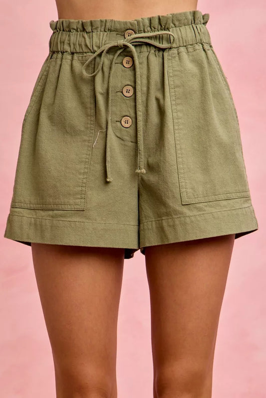 Olive green paperbag twill shorts with drawstring waist and patch pockets on model