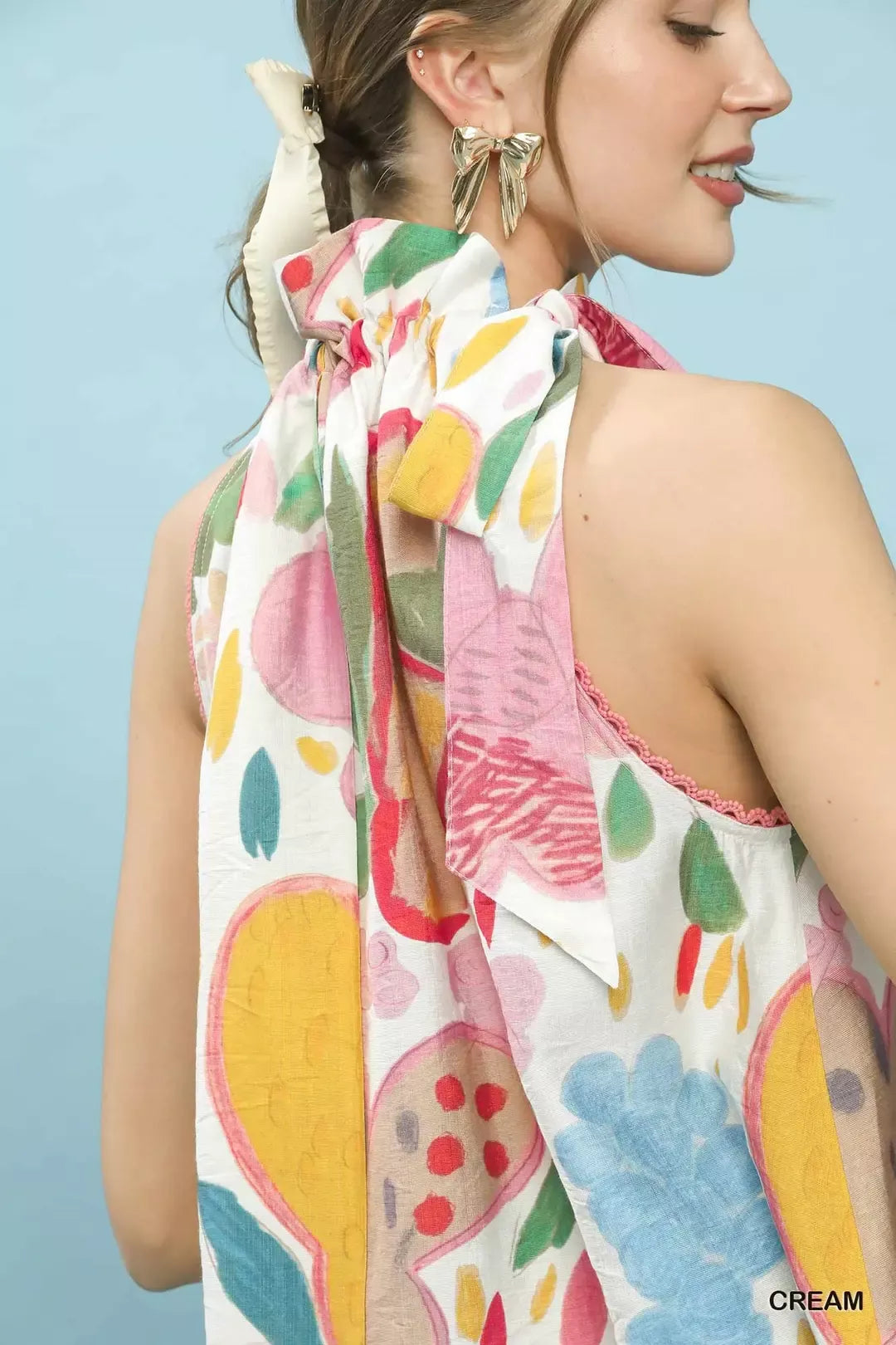 Multi-color floral halter neck boho top with ruffle detail, lace trim, and relaxed flowy fit styled with dark denim.