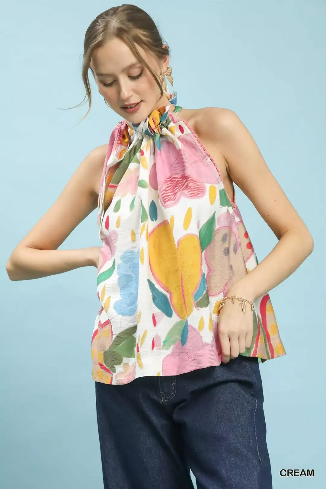 Multi-color floral halter neck boho top with ruffle detail, lace trim, and relaxed flowy fit styled with dark denim.