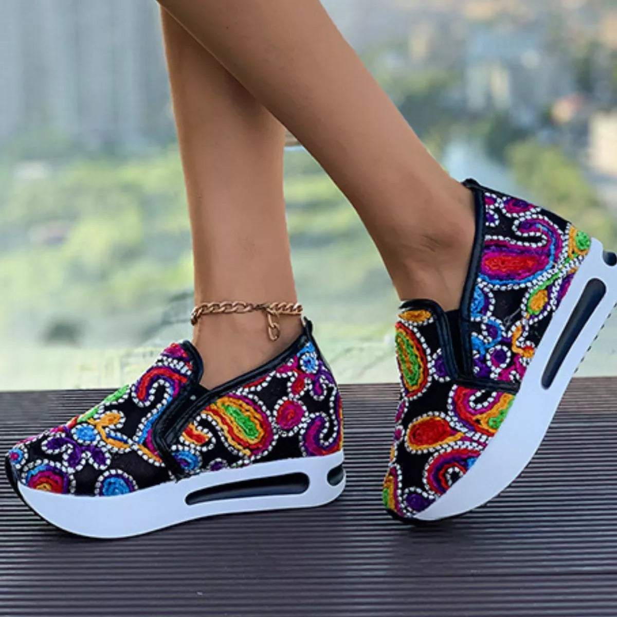 Colorful paisley slip-on sneakers in black and white options with flat rubber soles and easy casual style.