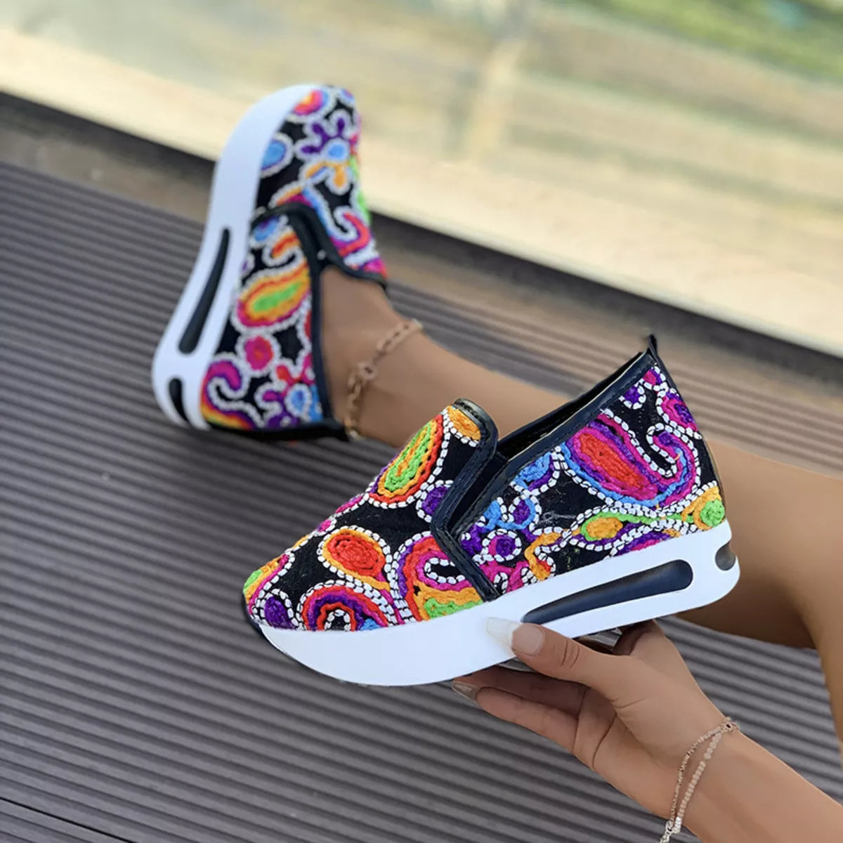 Colorful paisley slip-on sneakers in black and white options with flat rubber soles and easy casual style.
