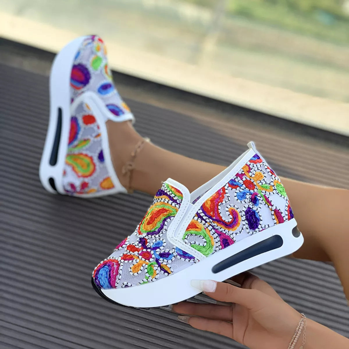 Colorful paisley slip-on sneakers in black and white options with flat rubber soles and easy casual style.