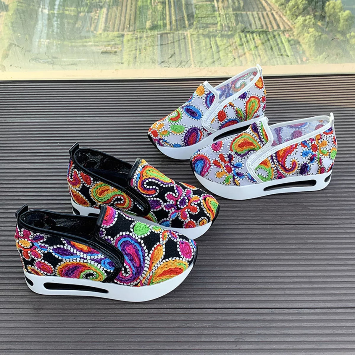 Colorful paisley slip-on sneakers in black and white options with flat rubber soles and easy casual style.