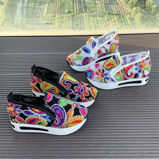 Colorful paisley slip-on sneakers in black and white options with flat rubber soles and easy casual style.