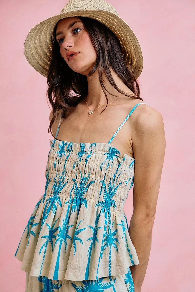 Palm print smocked cami top with adjustable straps, flowy silhouette, and tropical blue palm tree design.