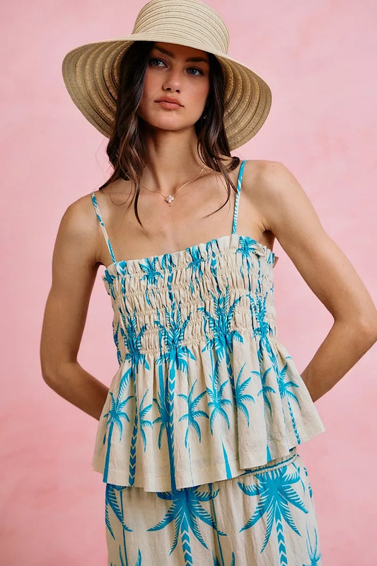 Palm print smocked cami top with adjustable straps, flowy silhouette, and tropical blue palm tree design.