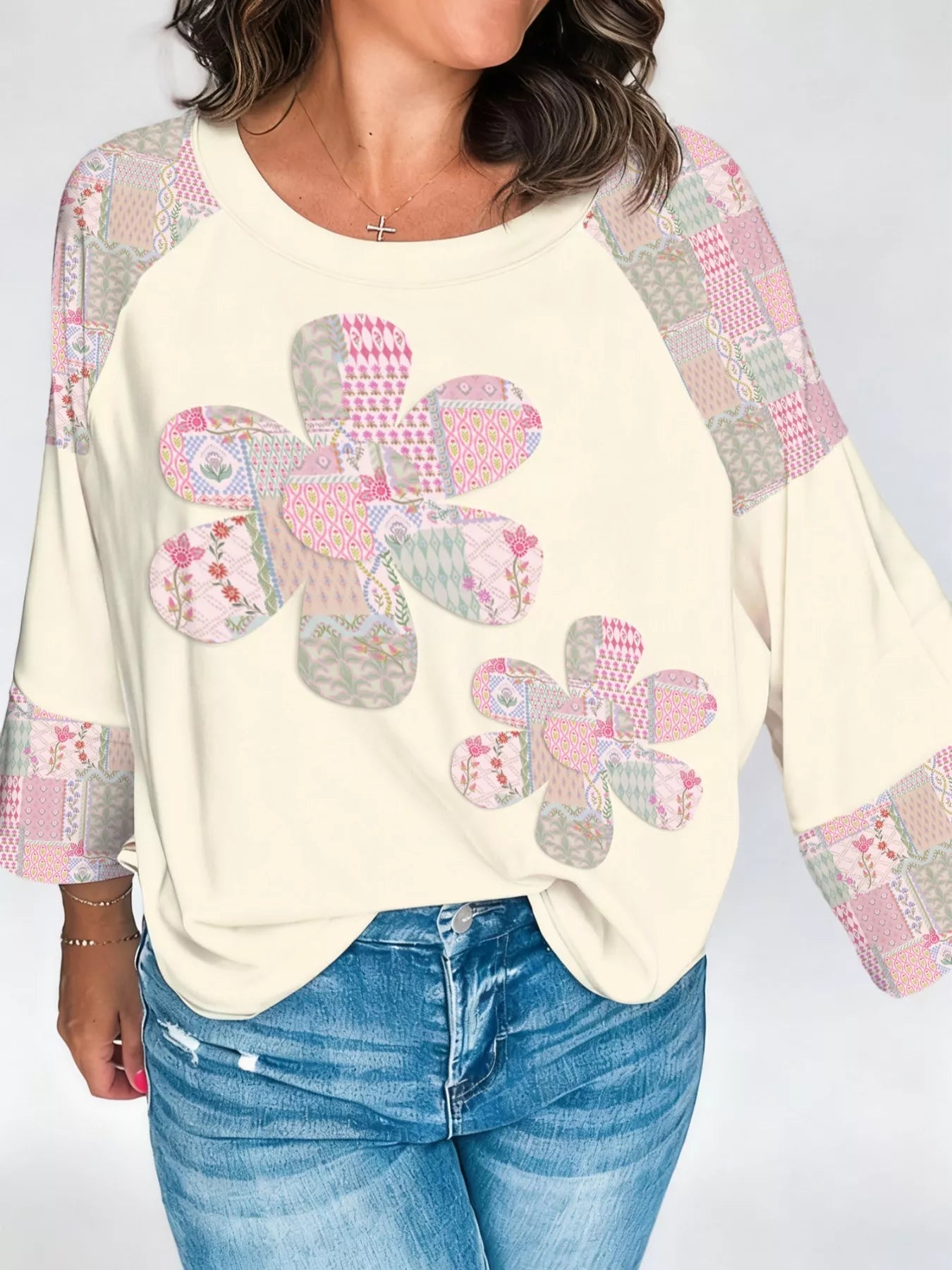 Cream pullover with patchwork floral appliqué and patterned sleeves