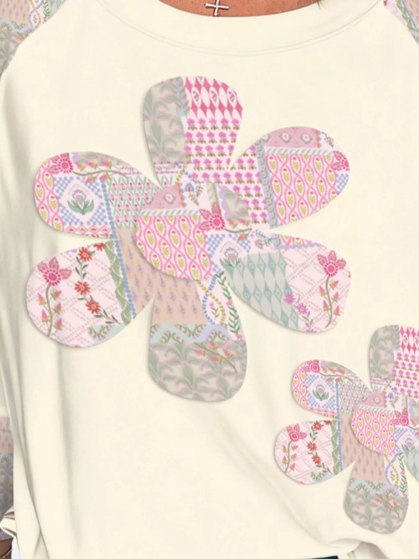 Cream pullover with patchwork floral appliqué and patterned sleeves
