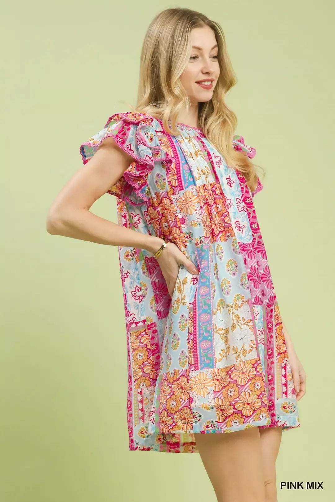 Colorful patchwork mini dress with ruffled flutter sleeves, lined body, floral prints, and breezy boho-inspired style.