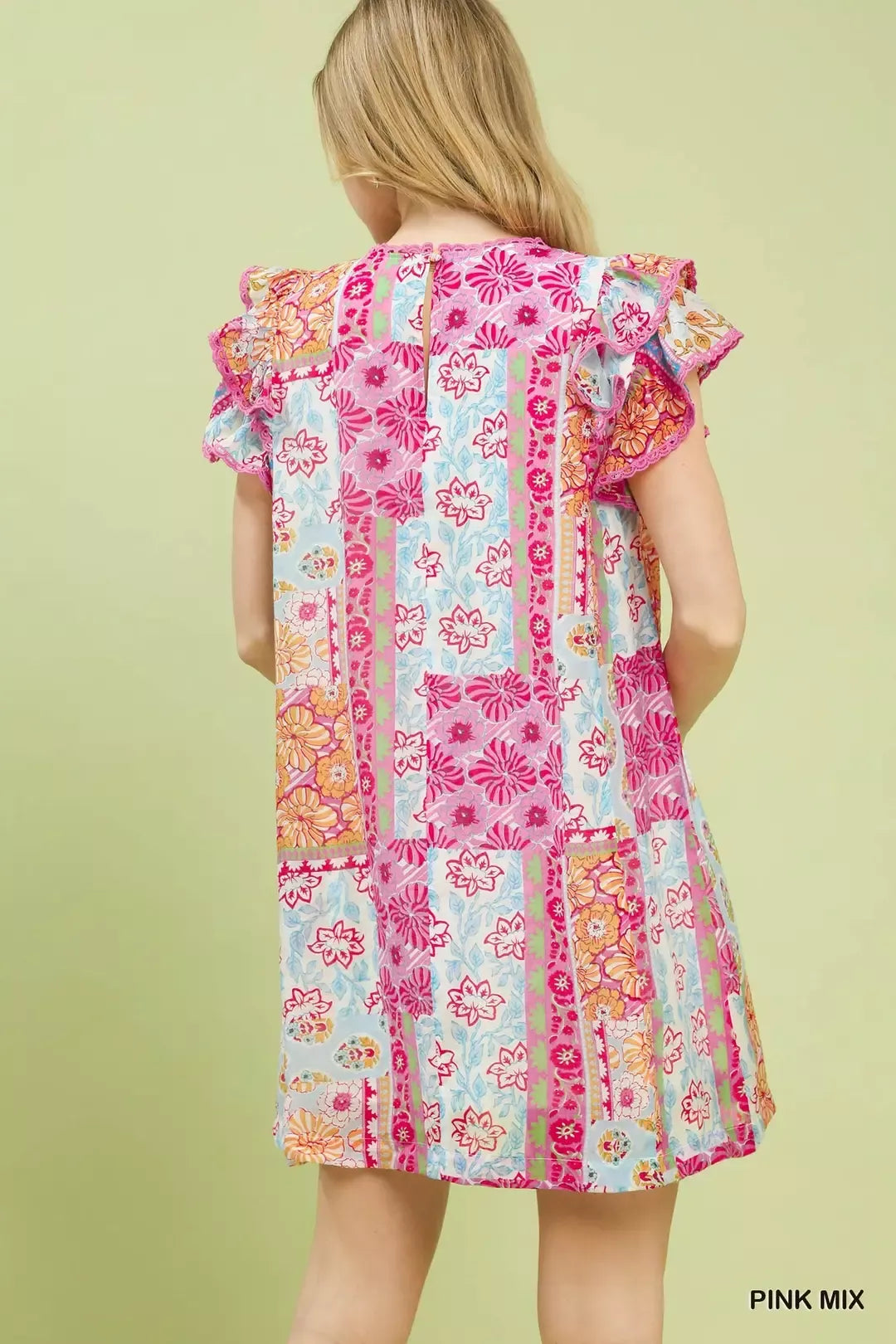 Colorful patchwork mini dress with ruffled flutter sleeves, lined body, floral prints, and breezy boho-inspired style.