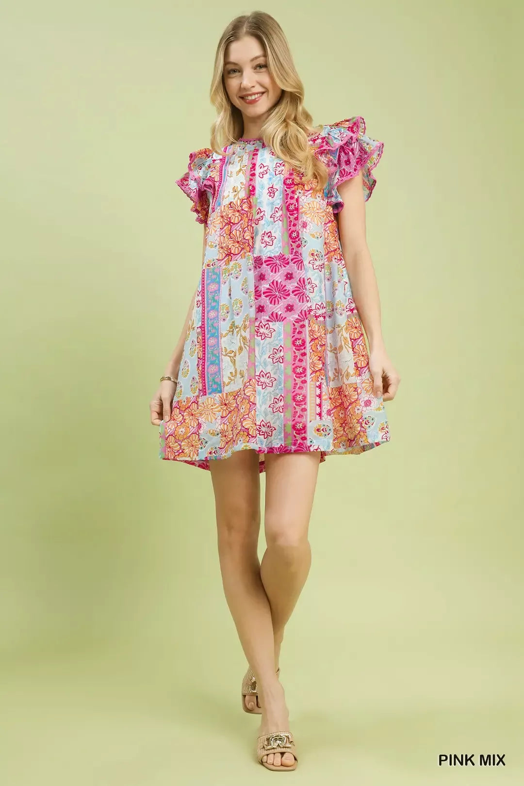 Colorful patchwork mini dress with ruffled flutter sleeves, lined body, floral prints, and breezy boho-inspired style.