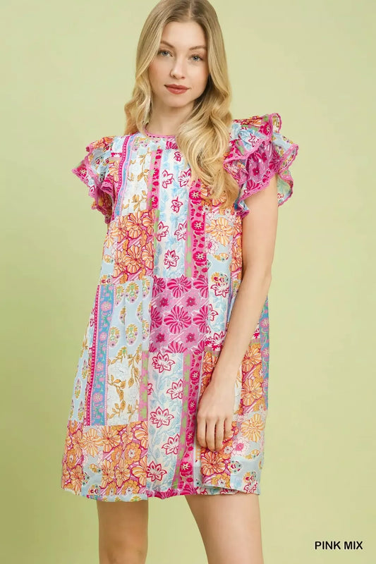 Colorful patchwork mini dress with ruffled flutter sleeves, lined body, floral prints, and breezy boho-inspired style.
