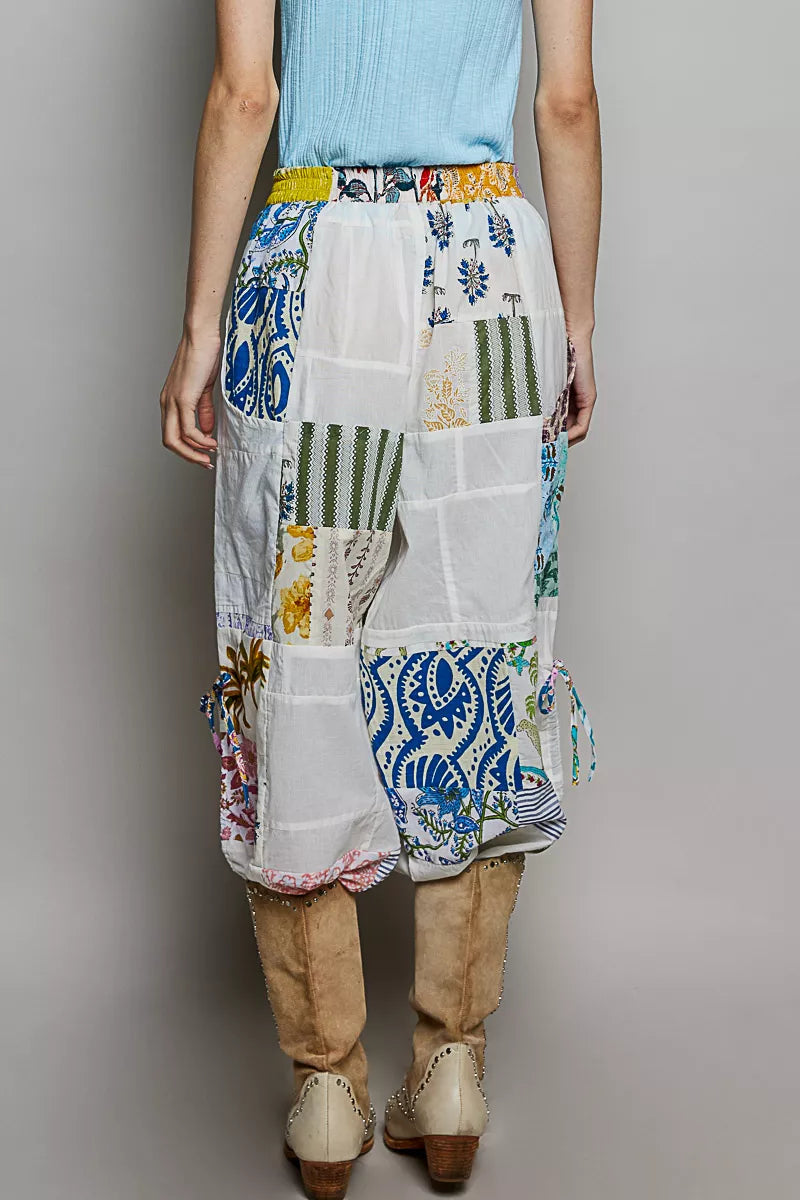 Wide-leg white patchwork cotton pants with colorful mixed print panels and pockets