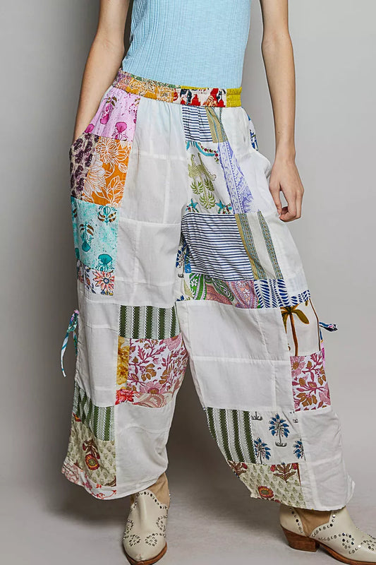 Wide-leg white patchwork cotton pants with colorful mixed print panels and pockets