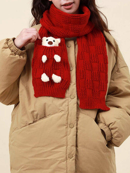 Knit winter scarf with teddy bear pocket detail worn over a jacket.
