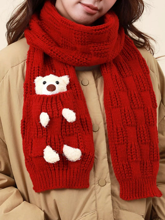 Knit winter scarf with teddy bear pocket detail worn over a jacket.