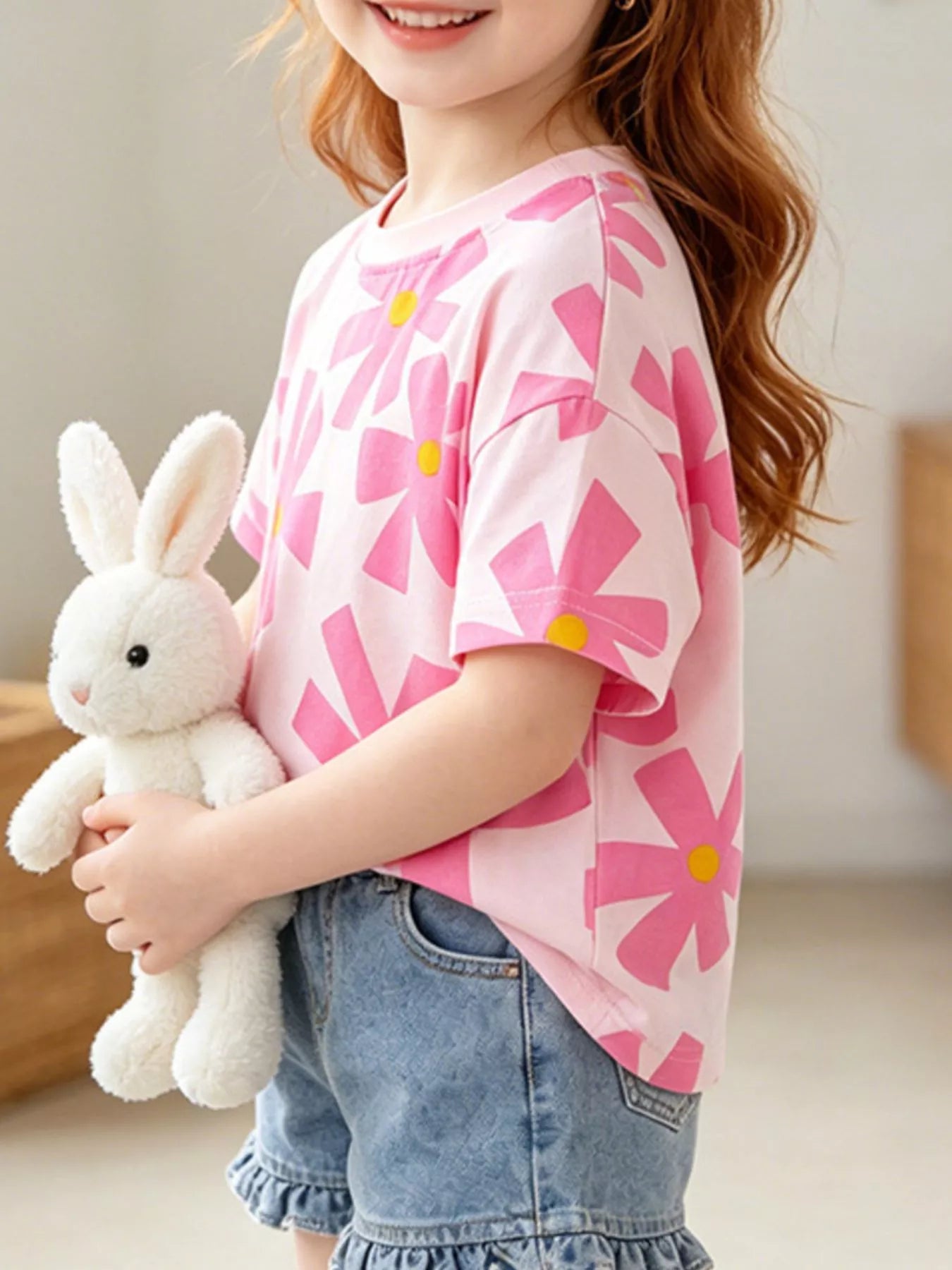 Girls pink short sleeve tee with oversized flower print, relaxed fit, and soft cotton-blend fabric styled with denim shorts.