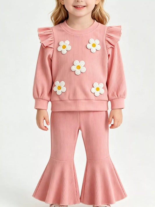 Children’s two-piece outfit with daisy appliqué details, ruffled shoulders, ribbed top, flared pants, and soft cotton-blend fabric.